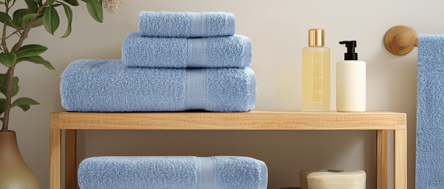 Stacked luxury bath towels and white bathrobes for hotel and spa hospitality supply